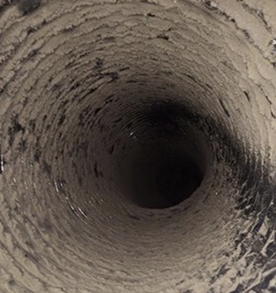 Air duct before cleaning, coated in dust and debris